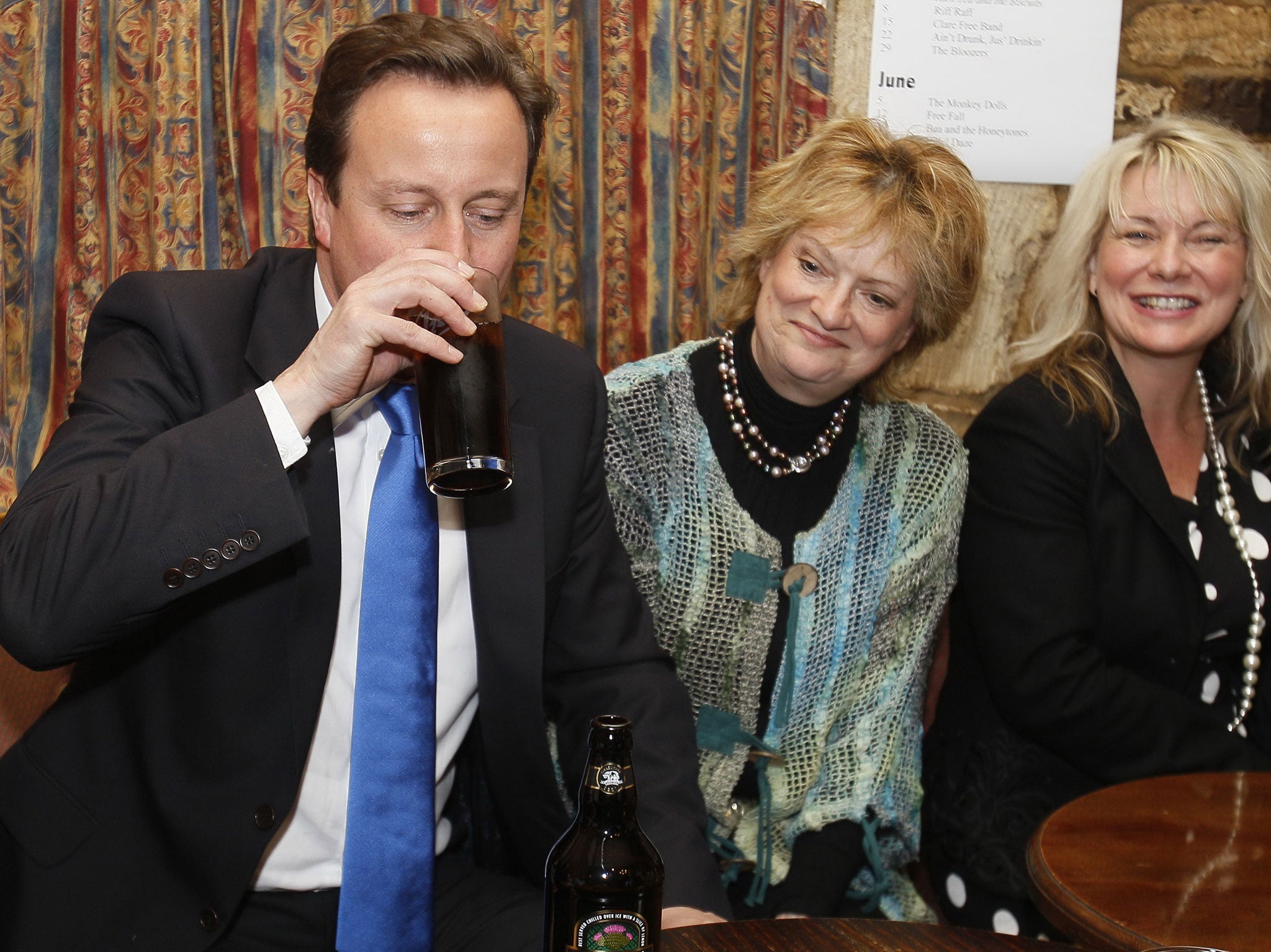 David Cameron (L) drinks a pint of beer at a public house in his constituency in Witney, Oxfordshire, England, in the early hours of Friday, May 7, 2010.