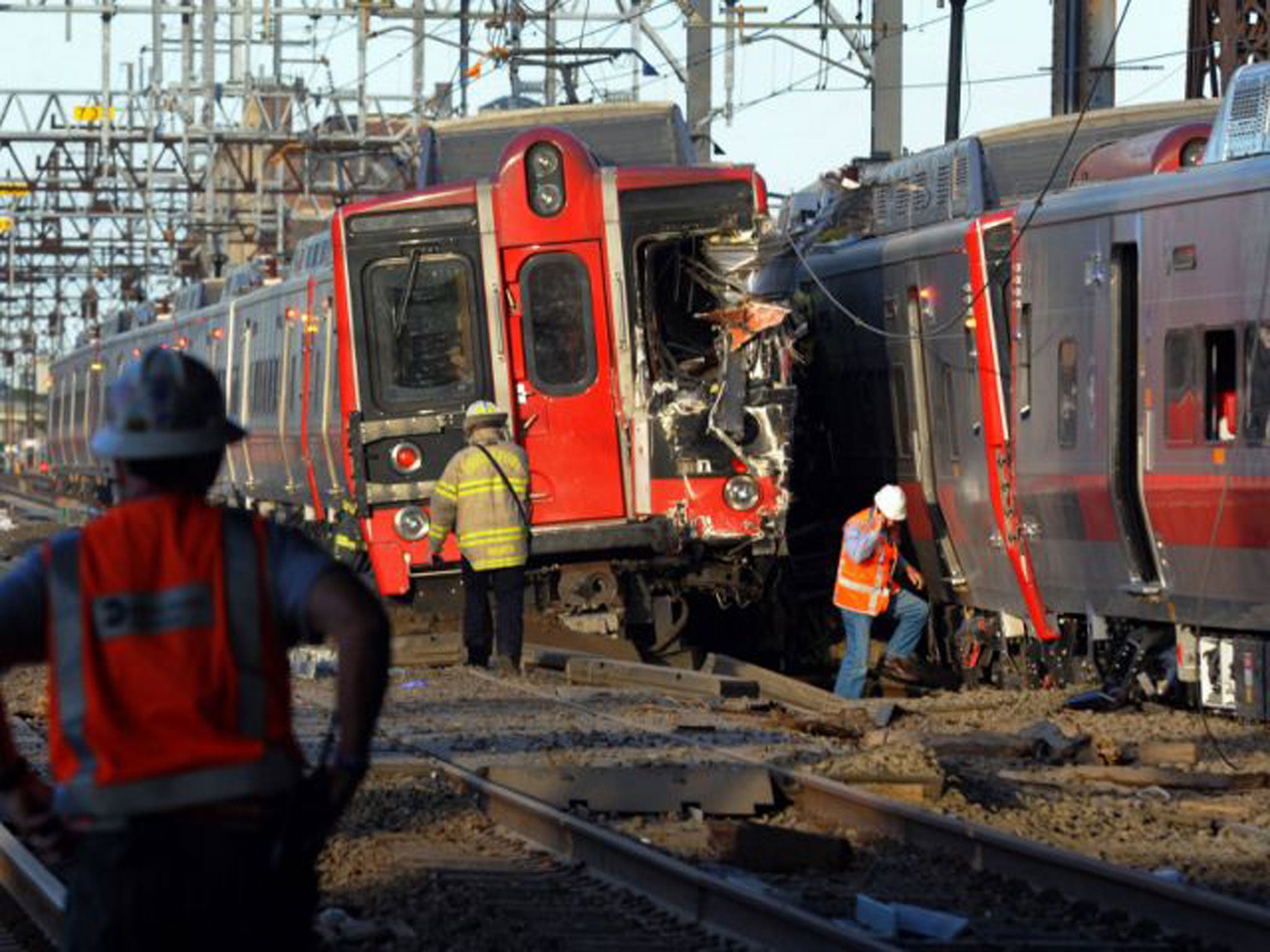 Emergency personnel work at the scene where two Metro North commuter trains collided near Fairfield, Connecticut