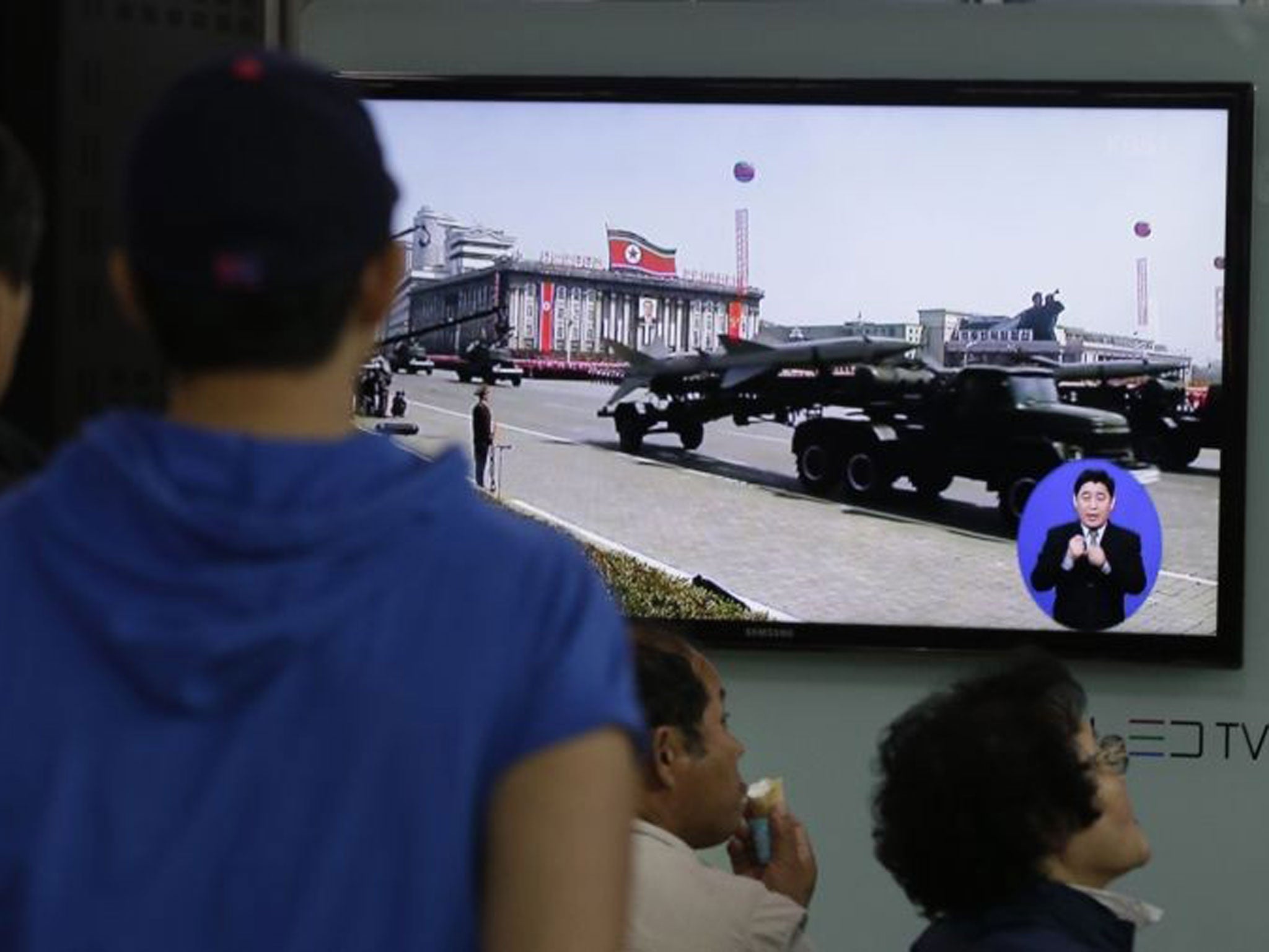 South Koreans watch TV news showing a footage of North Korean missiles