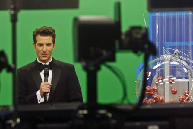 Host Sam Arlen speaks as the Powerball number (R) is about to be chosen at the Florida Lottery studio in Tallahassee May 18, 2013. The winning numbers are 22, 10, 13, 14, 52, and the Powerball number is 11. The Powerball jackpot is a record-setting $590.5