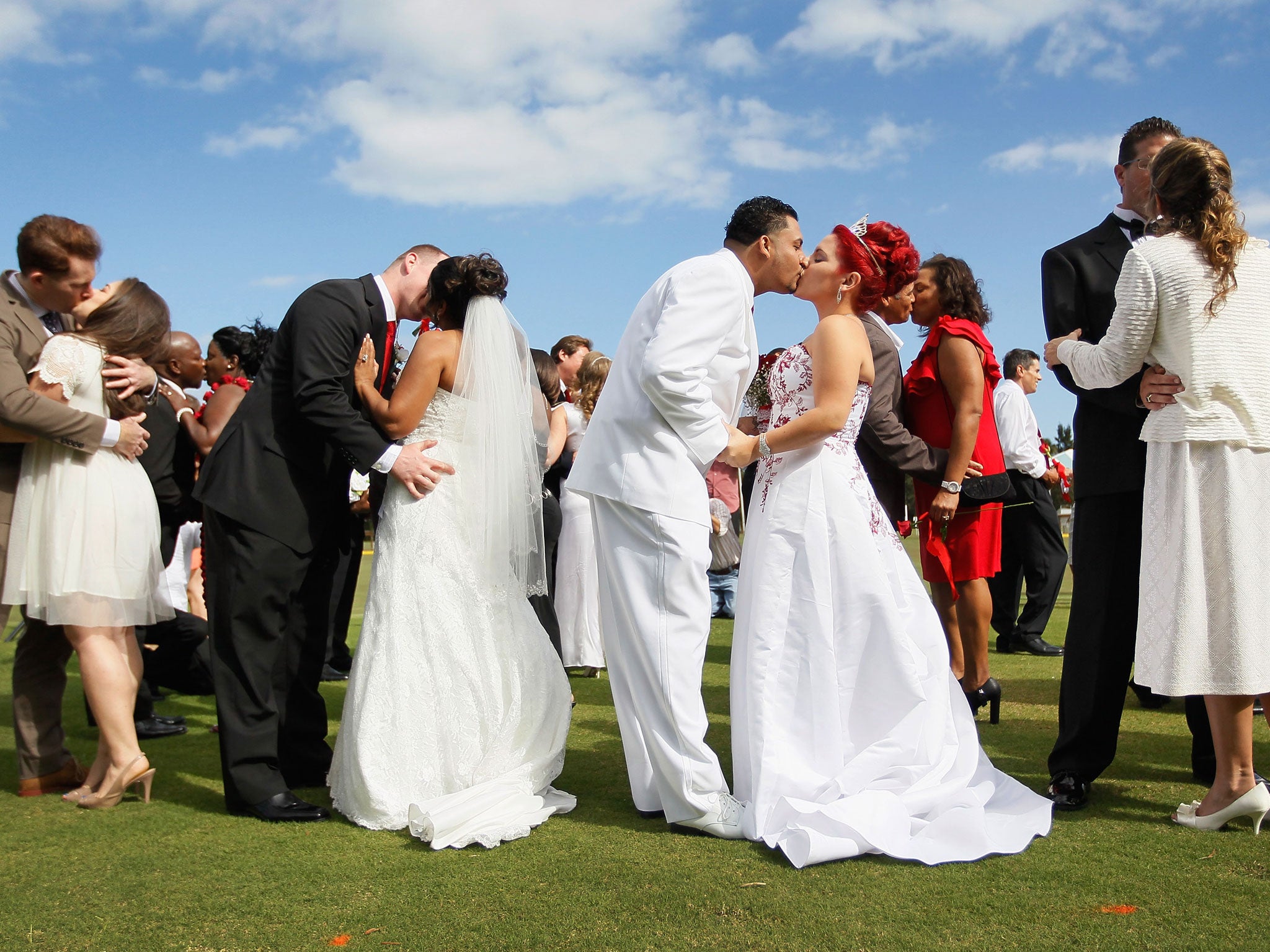 Jonah Klemm-Toole kisses his new wife, Elena Pizano, Kenny Dornhoefer kisses his new wife, Jaya Ganaishalm and Manuel Fuentes kisses his new wife, Monika Juarbe after being wed during a group Valentine's day wedding at the National Croquet Center on February 14, 2012 in West Palm Beach, Florida. The group wedding ceremony is put on by the Palm Beach Country Clerk & Comptroller's office and 30 couples to tied the knot.