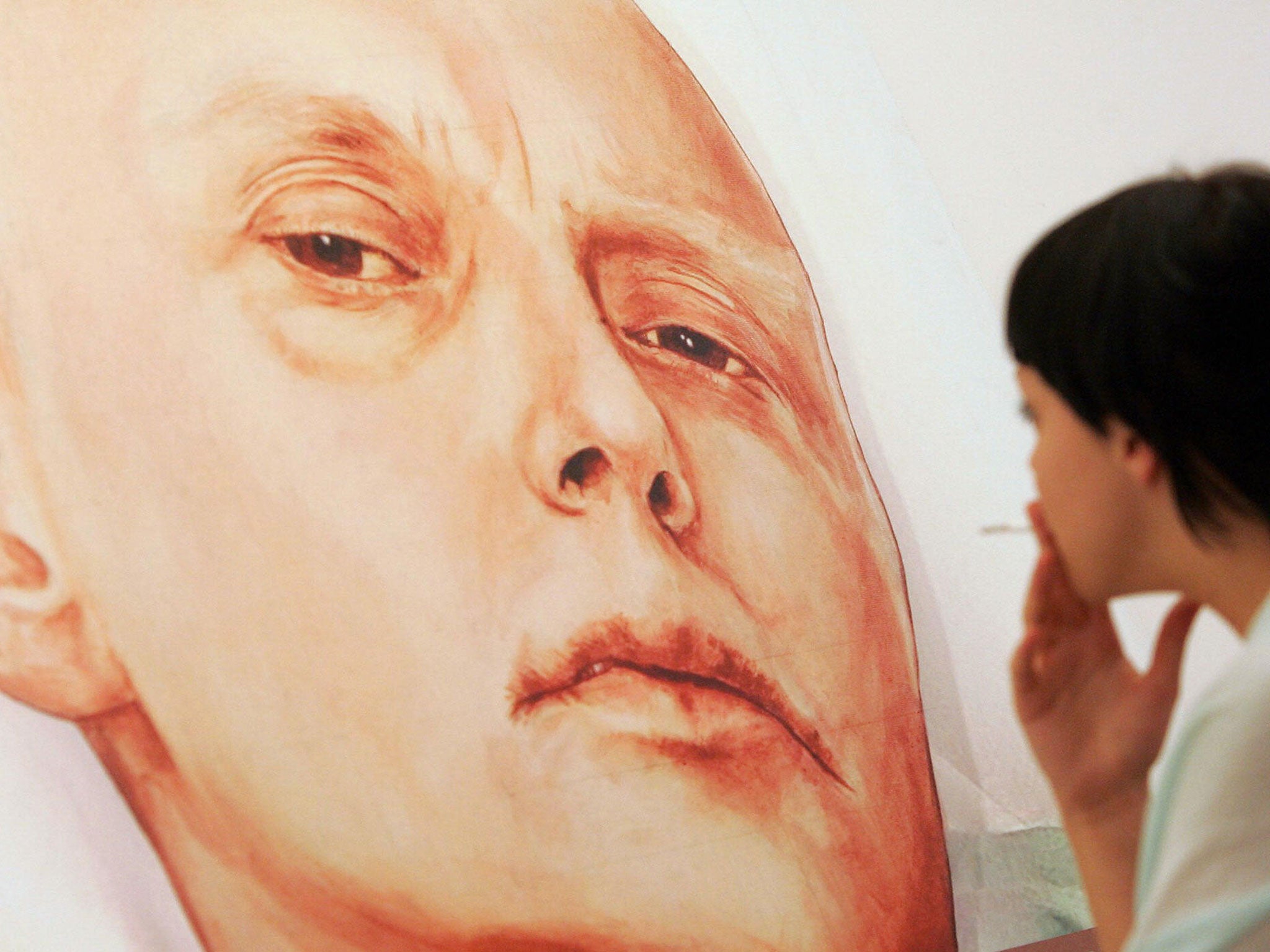 A visitor looks at a painting showing former Russian spy Alexander Litvinenko, by Dmitry Vrubel and Viktoria Timofeyeva painters in the Marat Guelman gallery in Moscow, 23 May 2007.