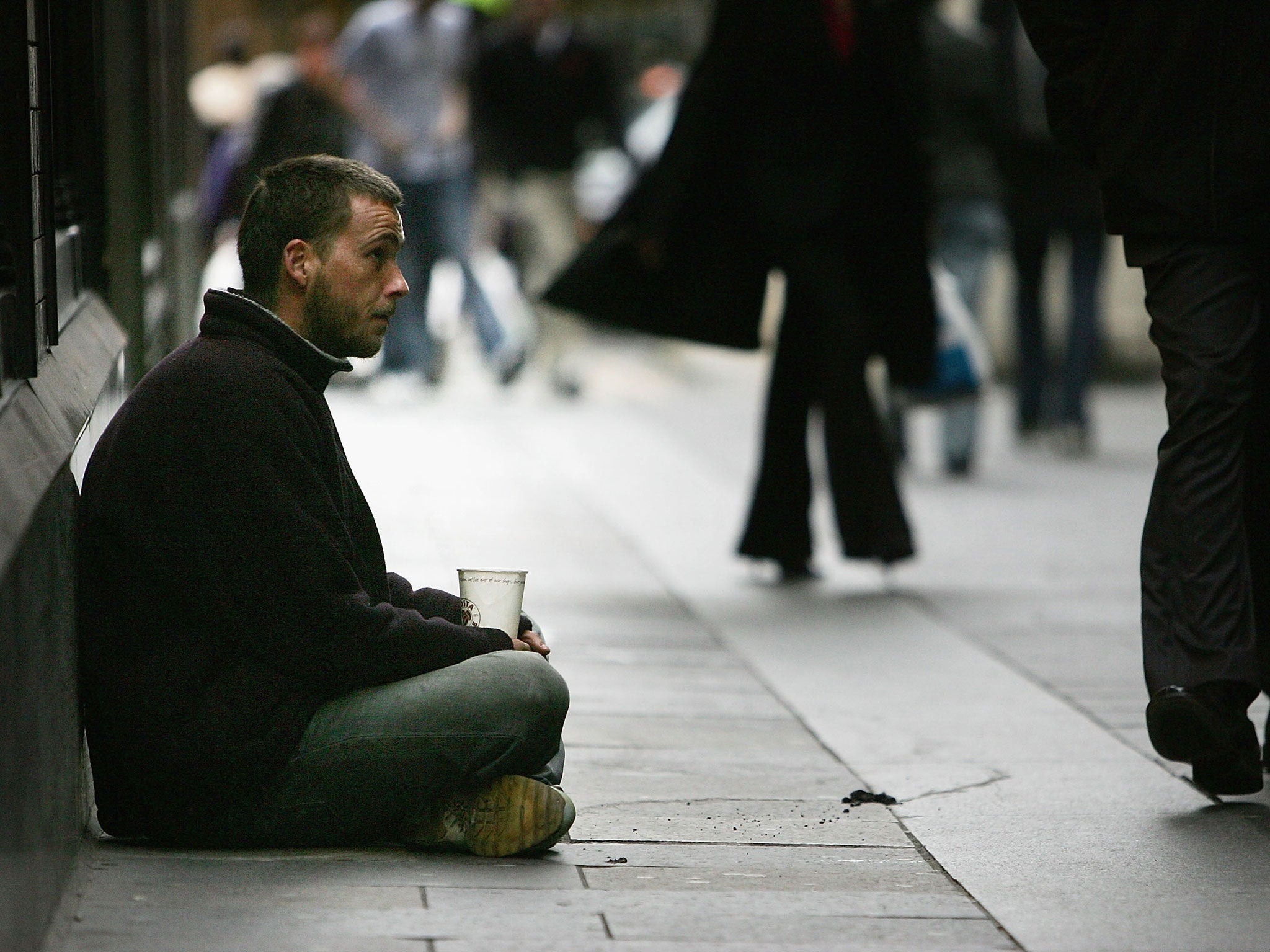 A homeless man begs for small change on the streets of Glasgow, Scotland.