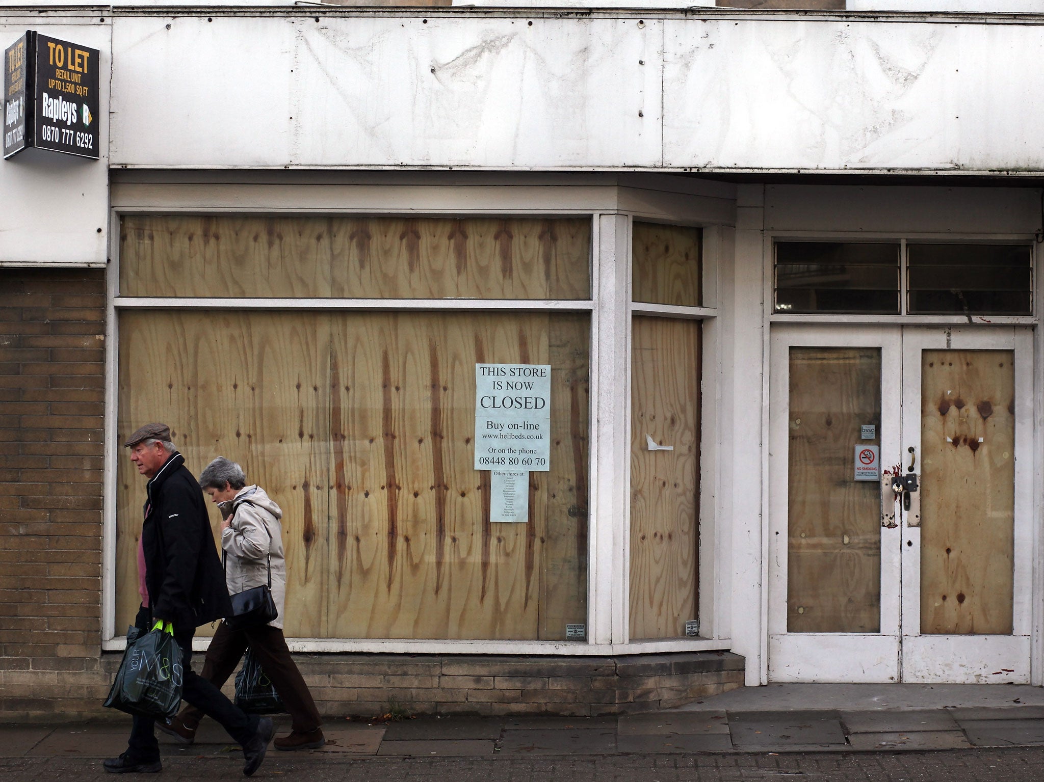 People pass empty and boarded up shops in the centre of Bath on December 28, 2011 in Bath, England