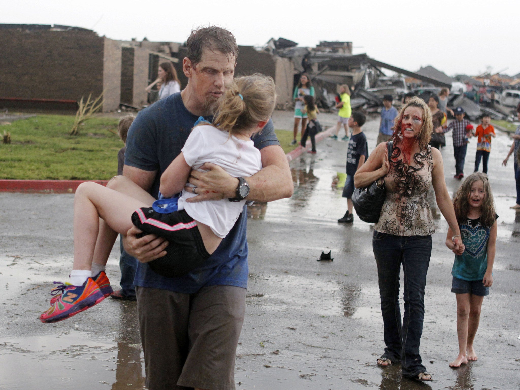 Teachers carry children away from Briarwood Elementary school after a tornado destroyed the school in south Oklahoma City