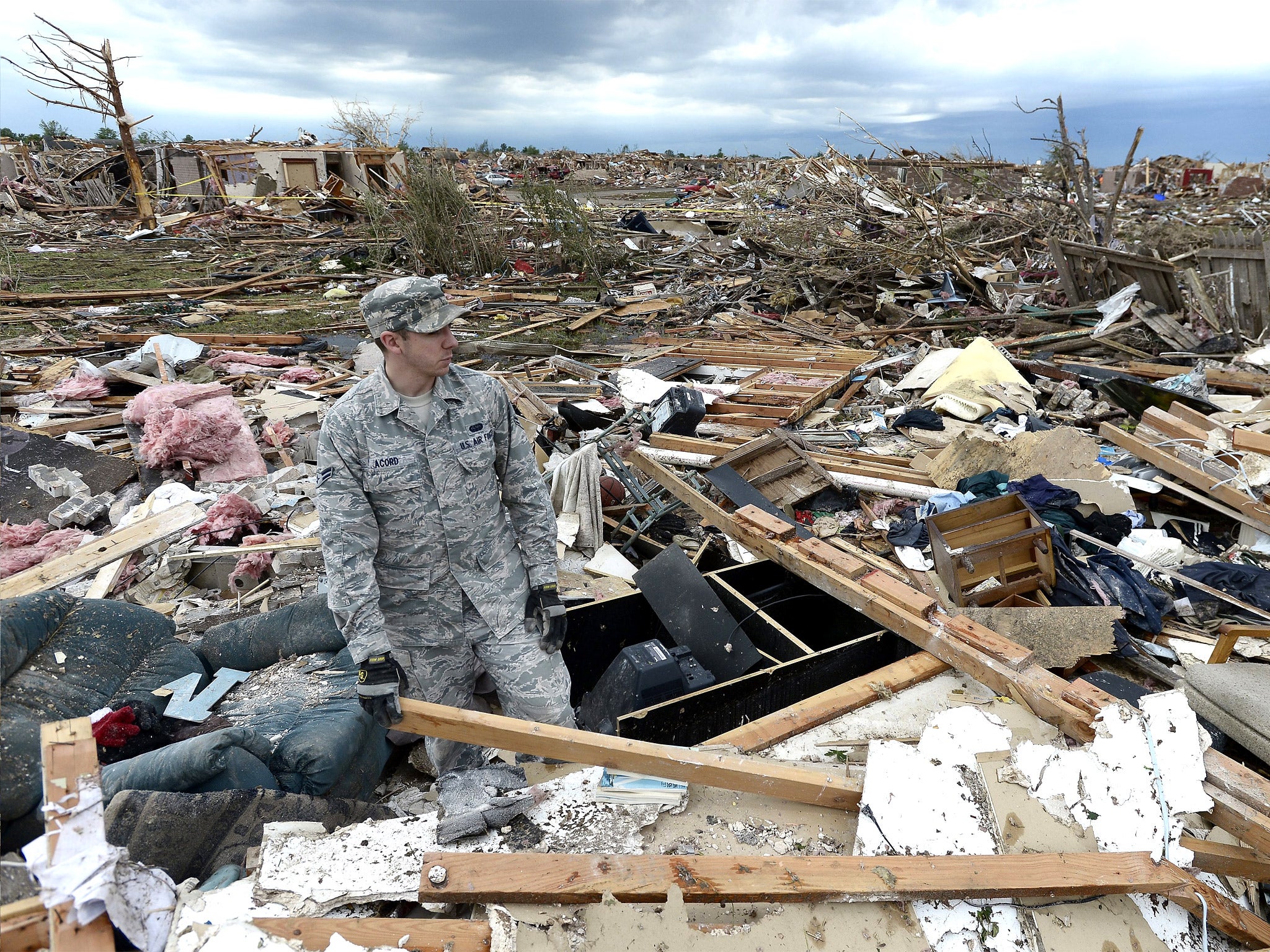 US Air Force Airman First Class Justin Acord sifts through the rubble of his father-in-law’s home in Moore, Oklahoma