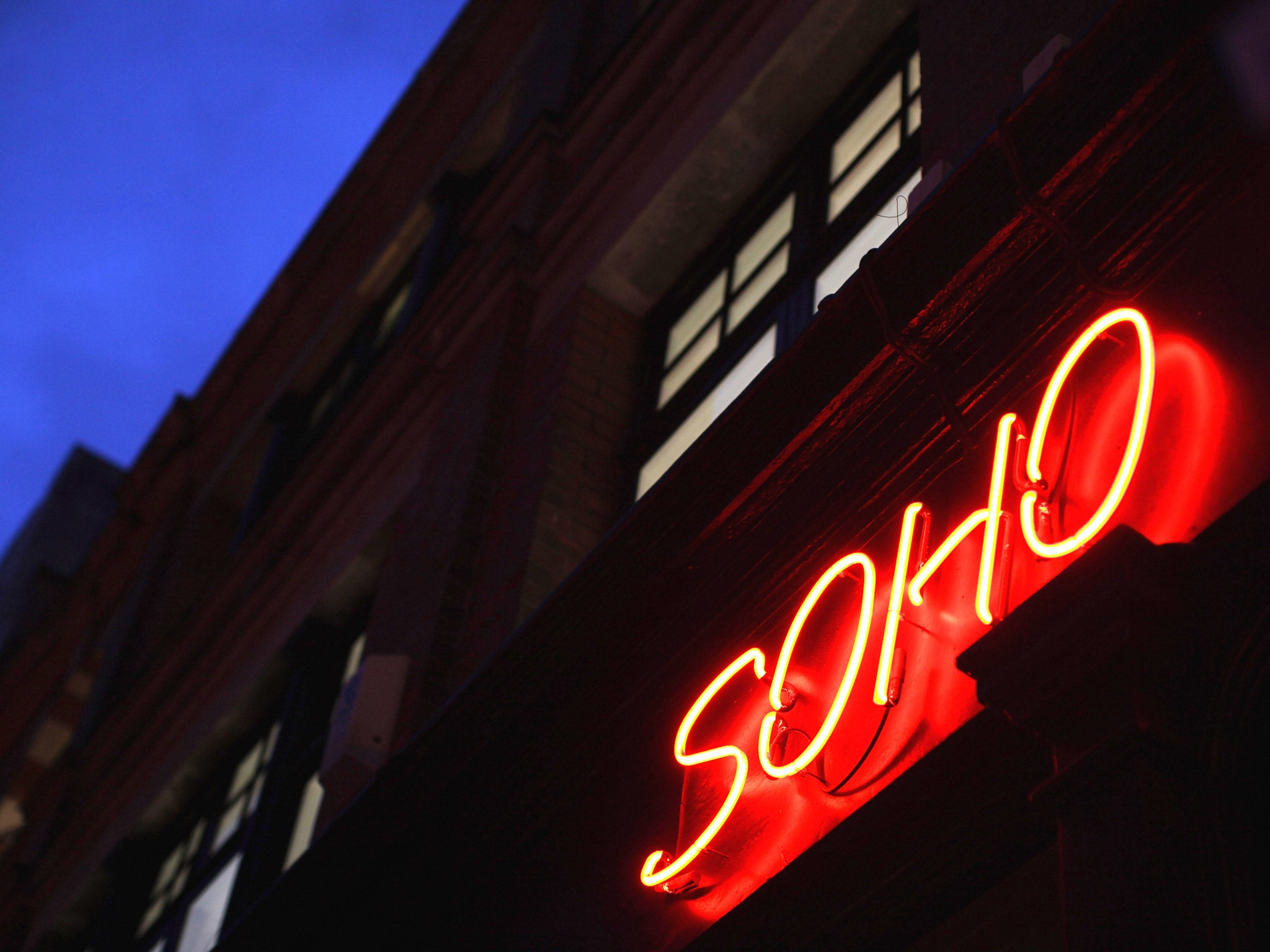 A red neon light illuminates a shop in Soho
