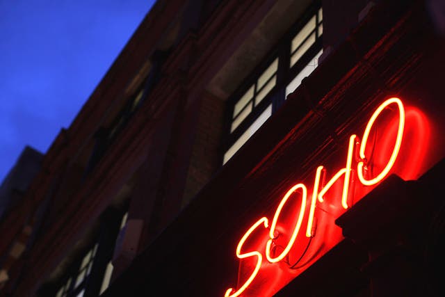 A red neon light illuminates a shop in Soho