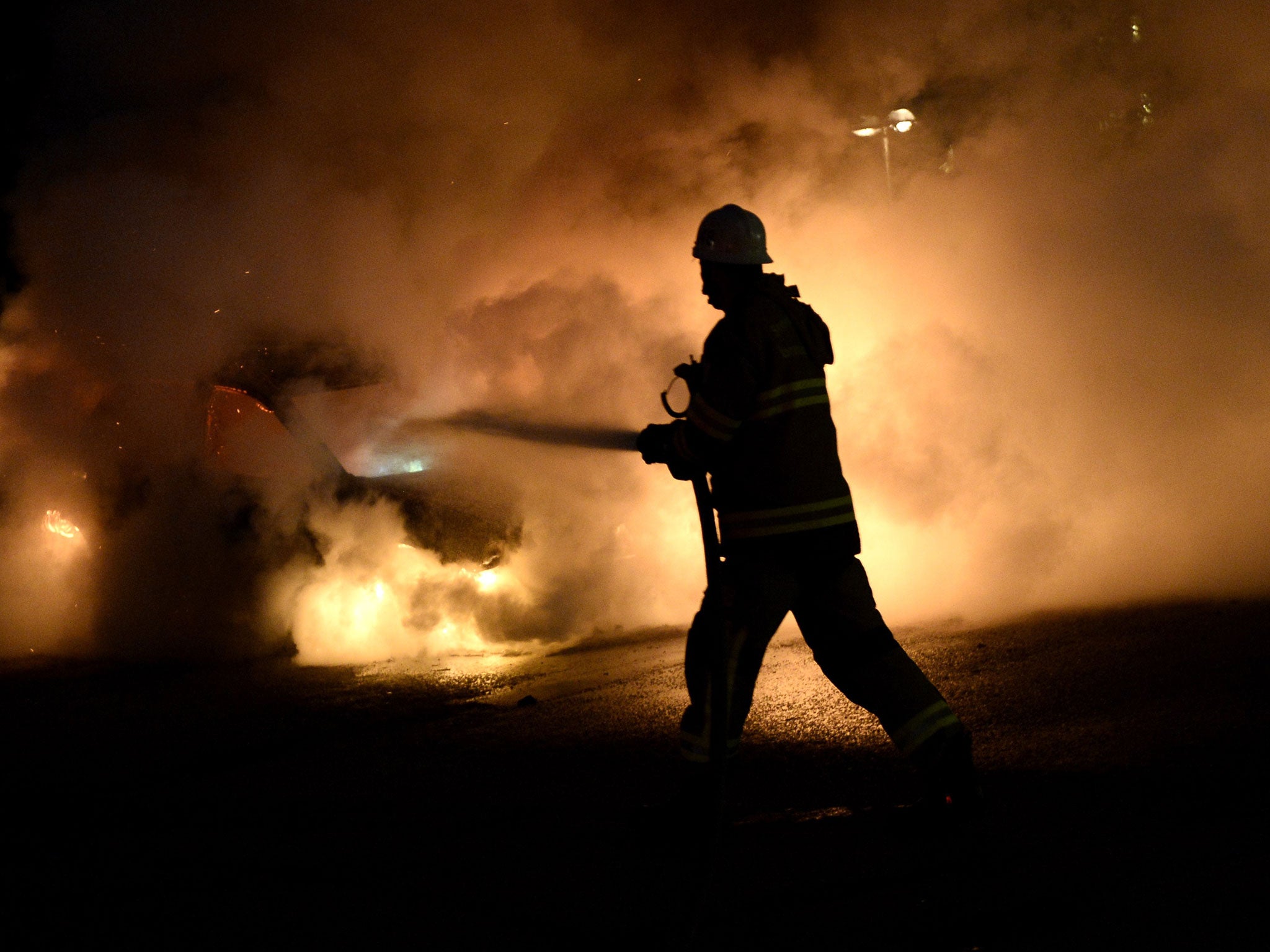 Firefighters douse a burning car in Kista, a Stockholm suburb, last week