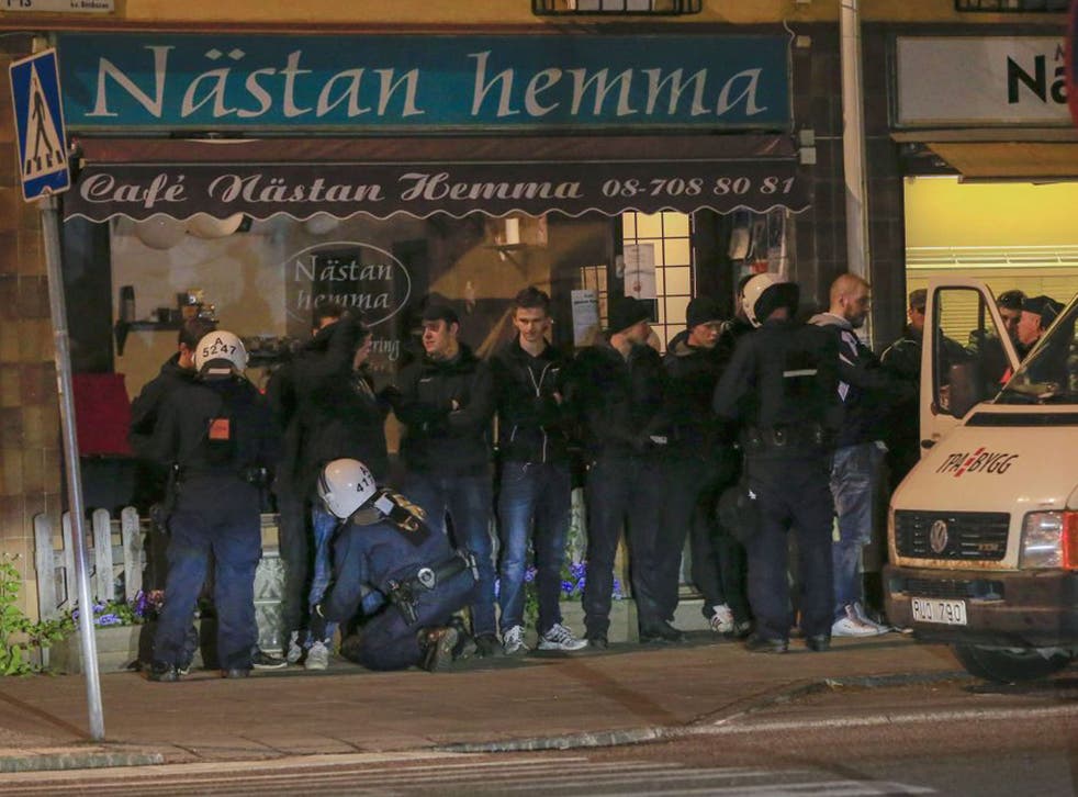 Police officers search young men lined up against a wall in a suburb of Stockholm (Fredrik Persson/AFP/Getty Images)