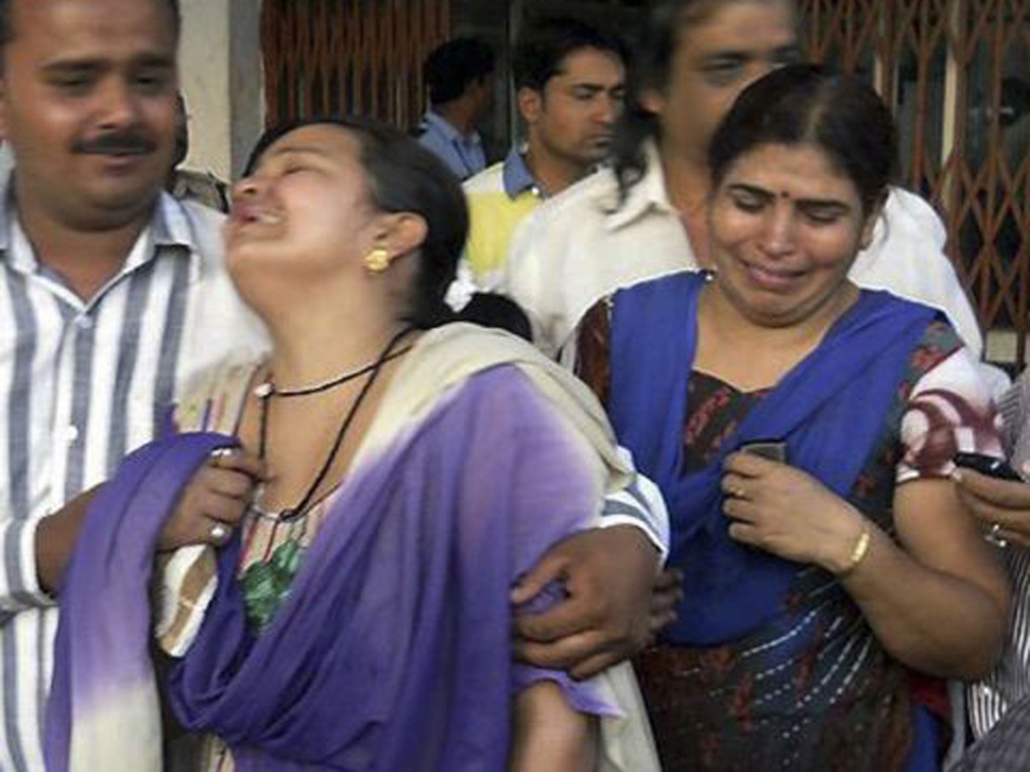 Unidentified relatives of an injured victim of a rebel attack cry outside a government hospital in Raipur, India
