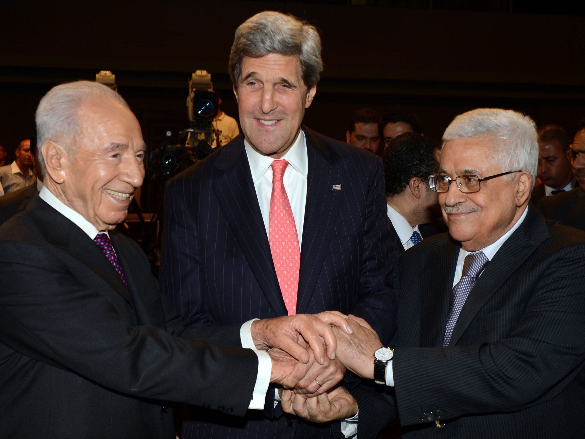 Mahmoud Abbas and Peres who posed for a three-way handshake with US Secretary of State John Kerry