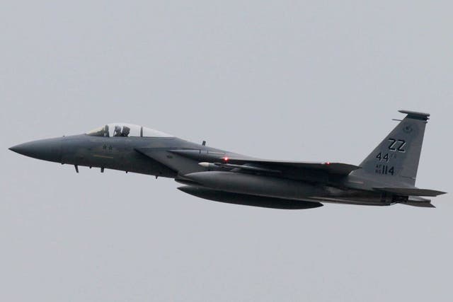 A US Air Force F-15 aircraft flying over the US air force Kadena Air Base in Kadena city, Okinawa