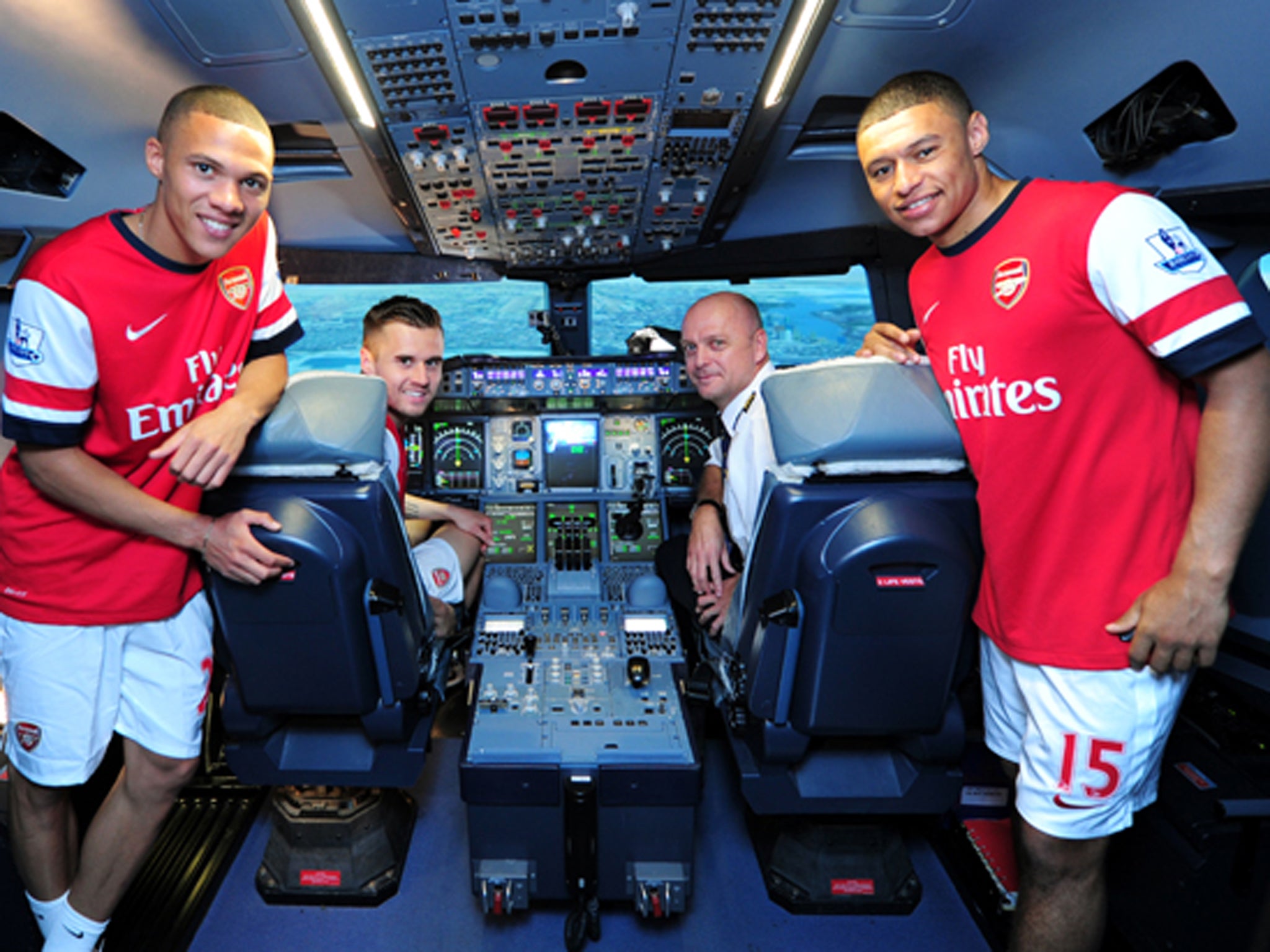 Kieran Gibbs, Carl Jenkinson, Captain Warren Coles and Alex Oxlade-Chamberlain in an A380 flight simulator at Emirates Aviation College in Dubai