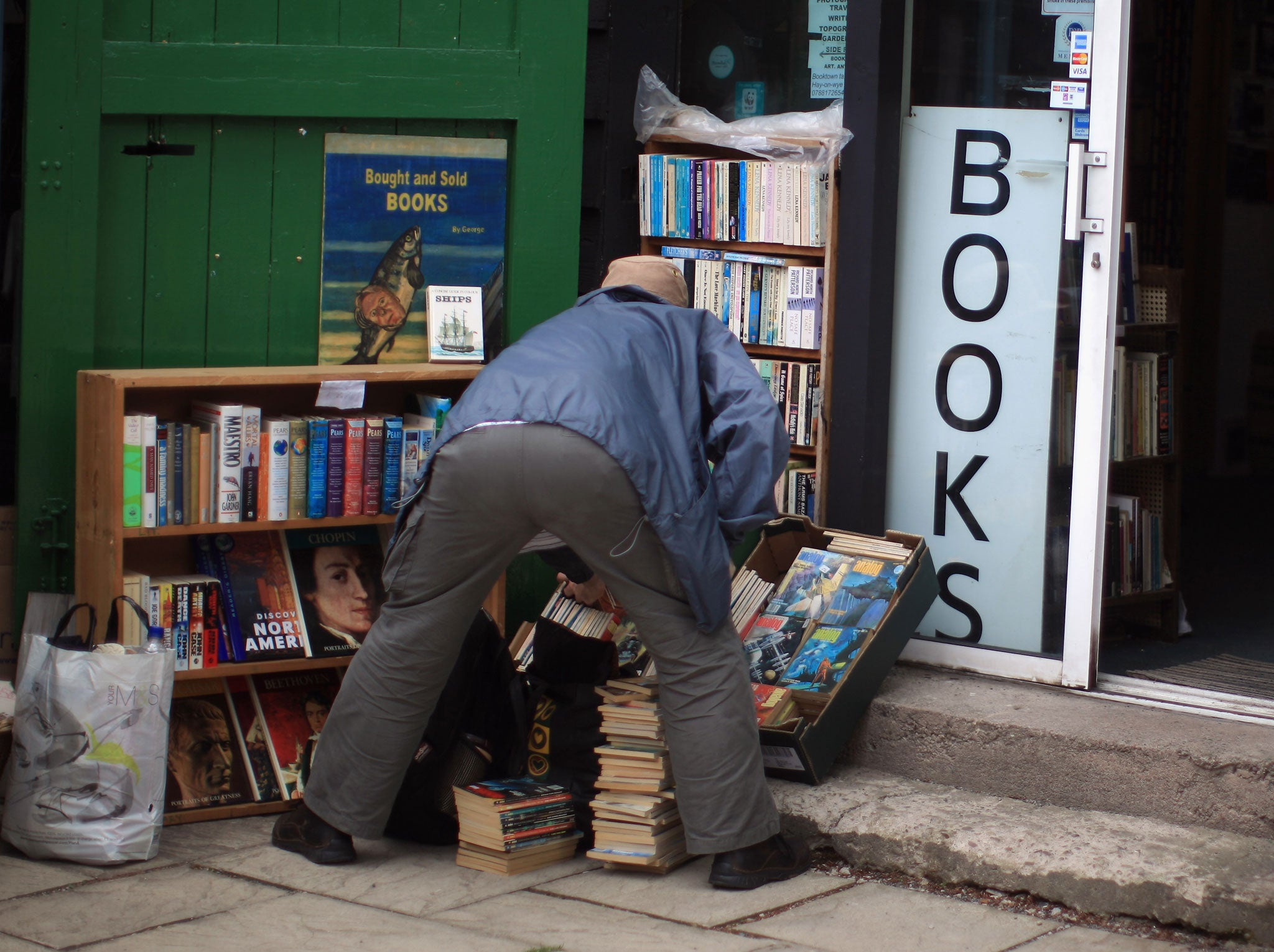 A man hunts for a bargain outside one of the many Hay-on-Wye bookshops during the Hay Festival on May 31, 2011 in Hay-on-Wye, Wales.