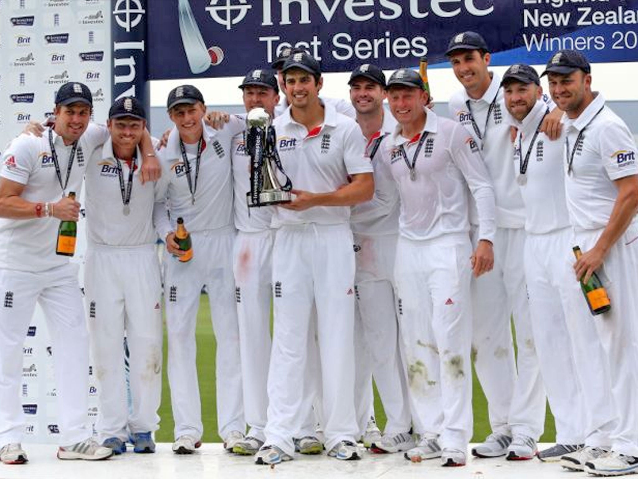 England's captain Alastair Cook, center, celebrates with trophy and his teammates after defeating New Zealand on the fifth day of the second Test match against New Zealand