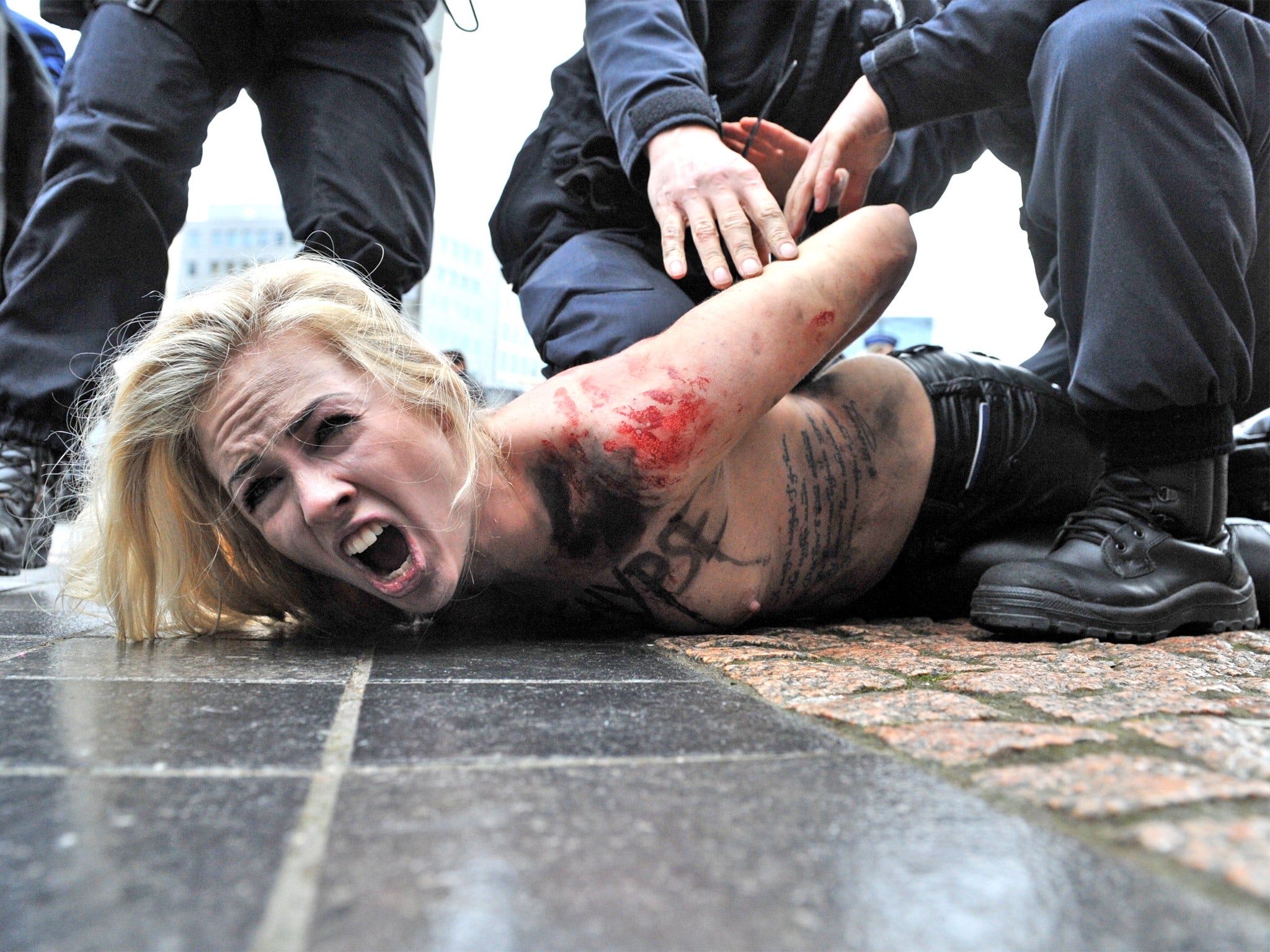 A Femen activist is taken away by police at the EU-Russia summit in Brussels in 2012