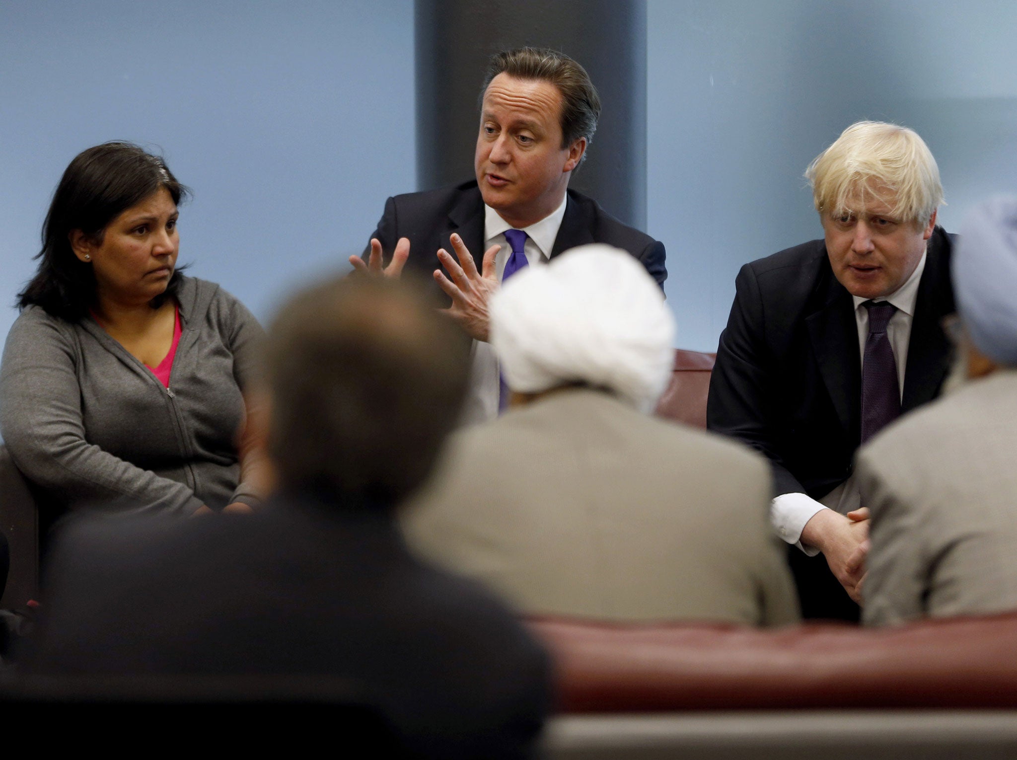 British Prime Minister David Cameron (C) and London Mayor Boris Johnson (R) meet with members of the local community during a visit to Woolwich, southeast London on May 23, 2013. Prime Minister David Cameron vowed that Britain would be resolute against violent extremism following the gruesome murder of a soldier by two suspected Islamists on a London street. After chairing a meeting of security chiefs the day after the soldier was hacked to death in broad daylight, he said Britain's communities would unite in condemning an attack he described as a 'betrayal of Islam'.