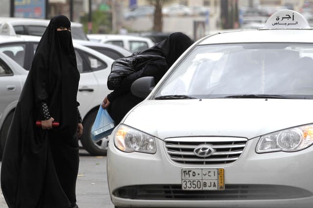 Saudi women, forbidden to drive, board a taxi in Riyadh
