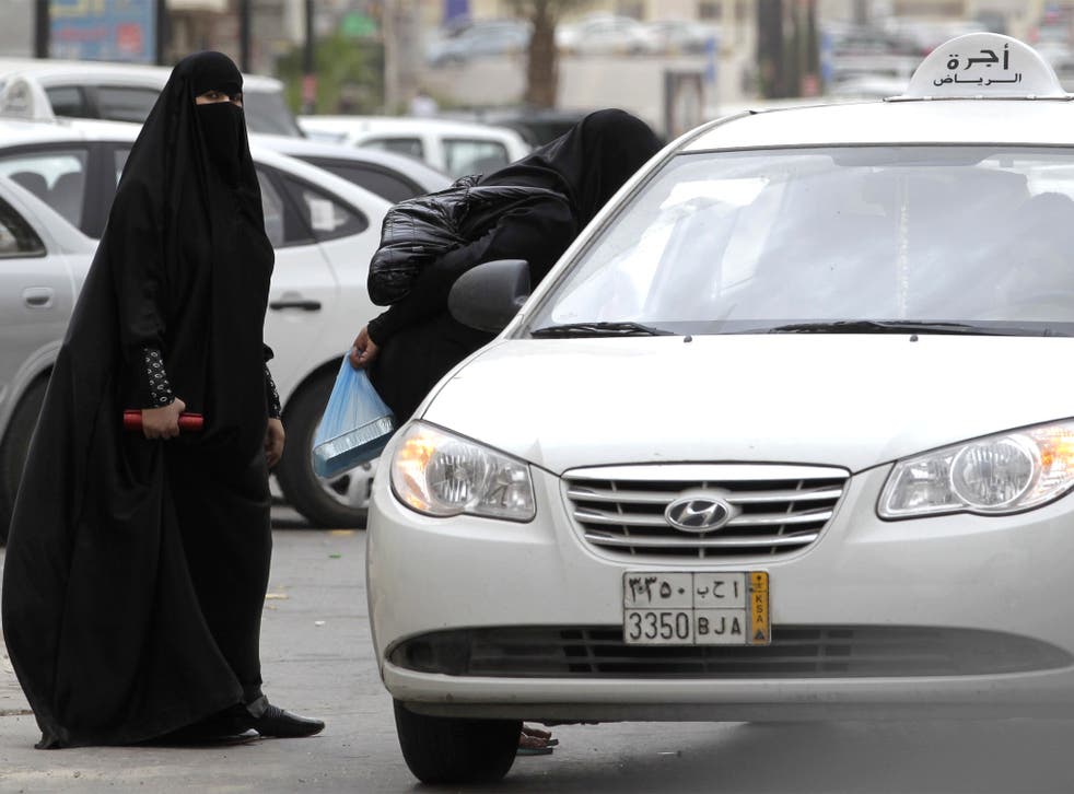 Saudi women, forbidden to drive, board a taxi in Riyadh