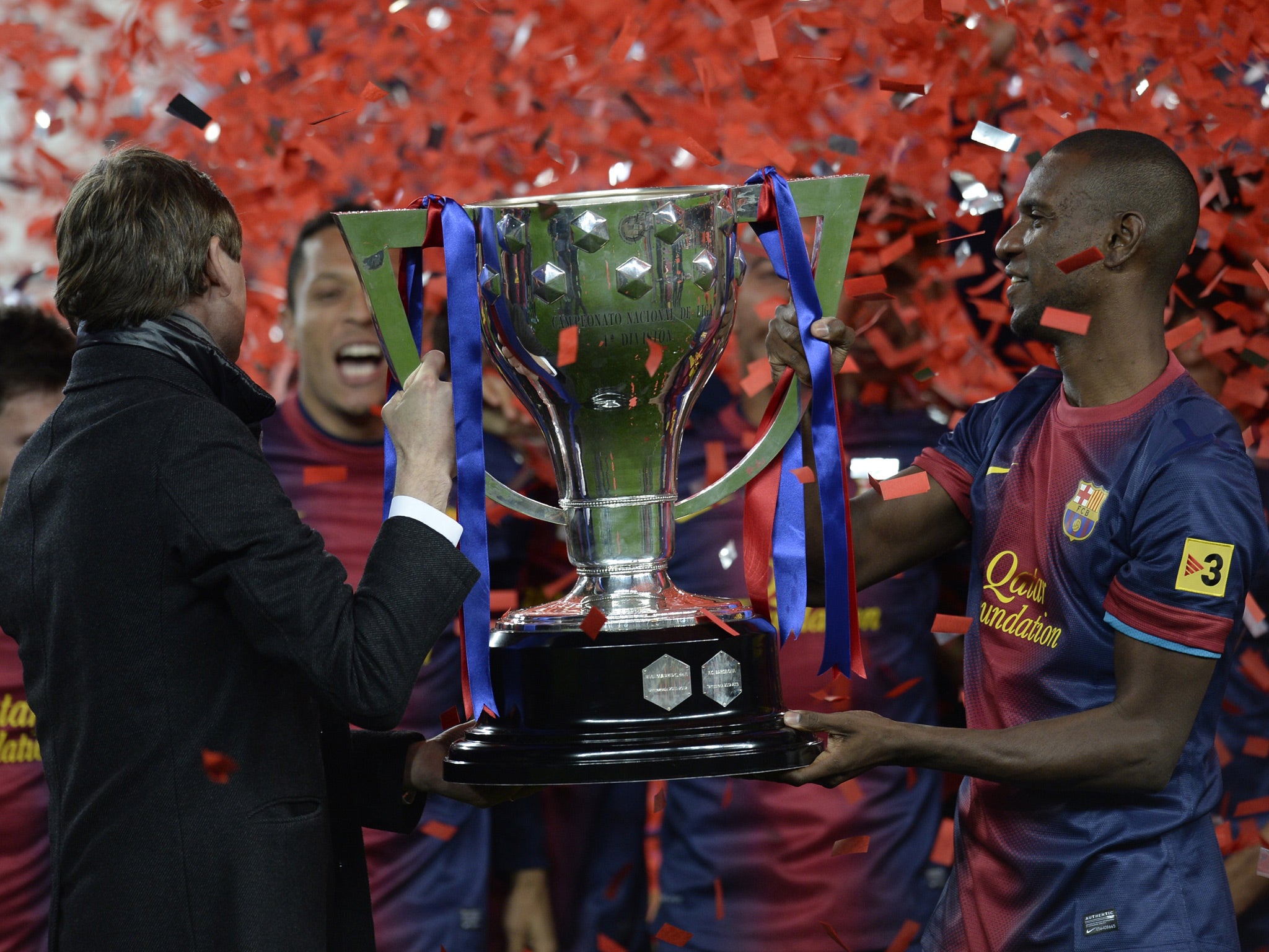 Tito Vilanova (L) and Eric Abidal life the league trophy during a ceremony at the Camp Nou