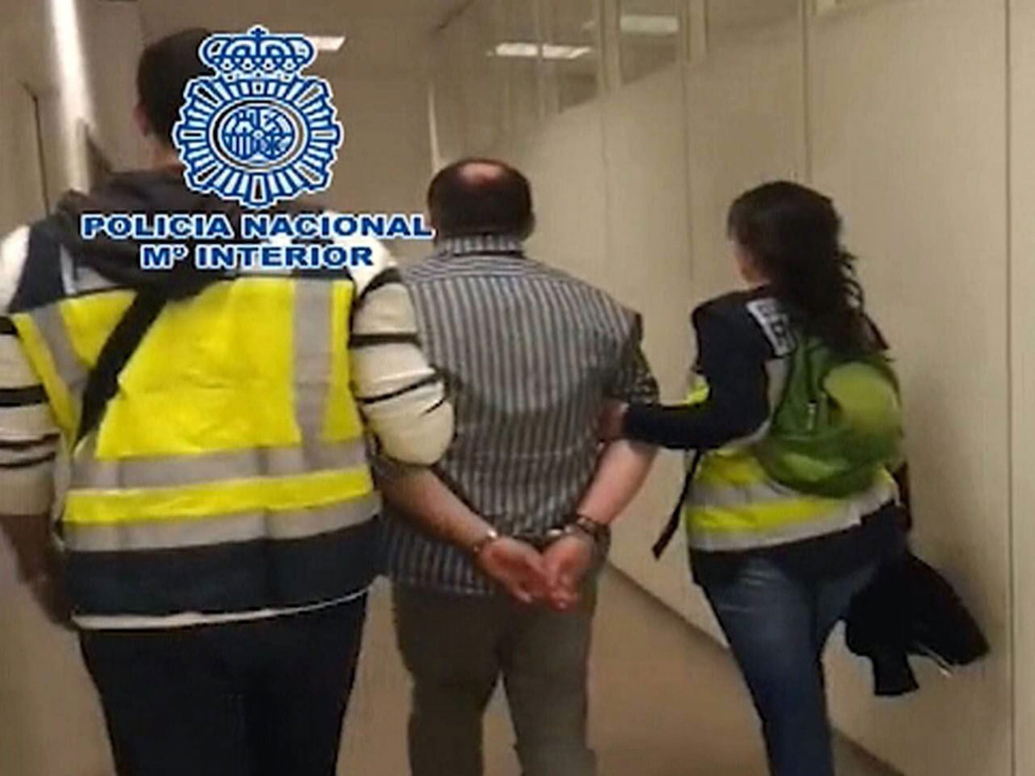 Spanish police officers detaining the Liberty Reserve founder Arthur Budovsky in Barajas airport, Madrid