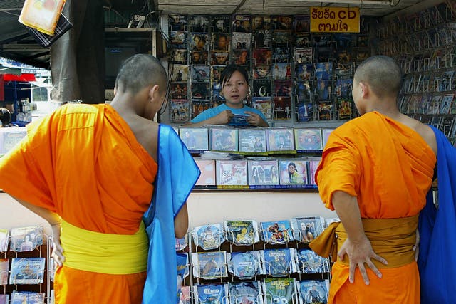 Two monks check out a CD shop selling pirated movies and music albums in Vientiane, the Laotian capital, 02 December 2004.