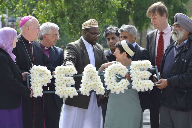 Local community representatives and faith leaders lay flowers near the scene of the killing of Lee Rigby's murder