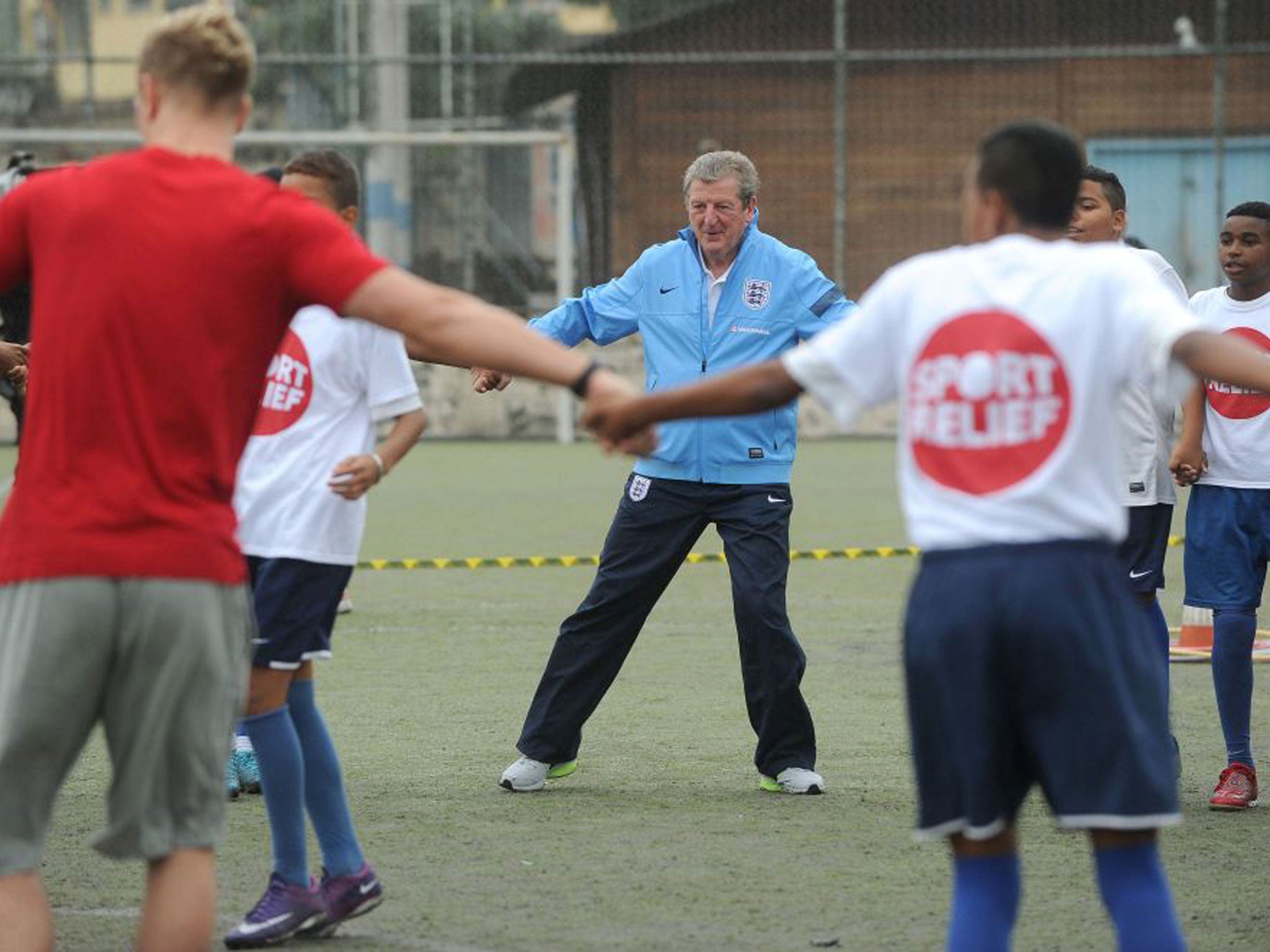 The England squad meet children from a Sport Relief-funded project in Rio de Janeiro yesterday