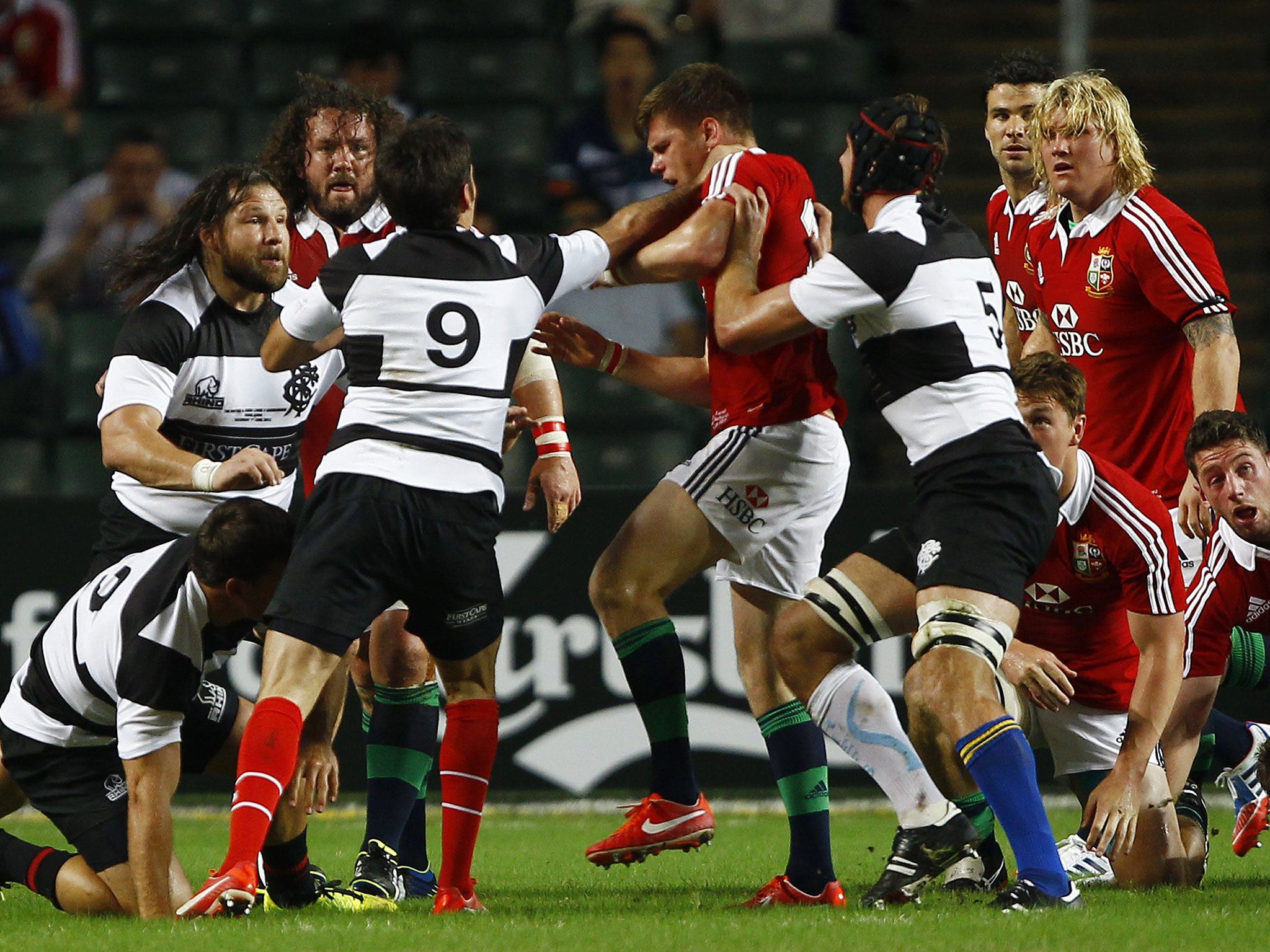 Barbarians’ Schalk Brits is on his knees, left, after striking Owen Farrell, centre, during the game