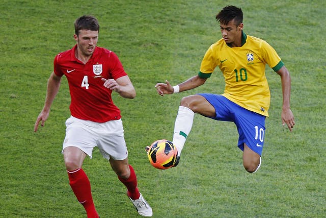 Brazil’s Neymar, right, takes the ball away from Michael Carrick, left