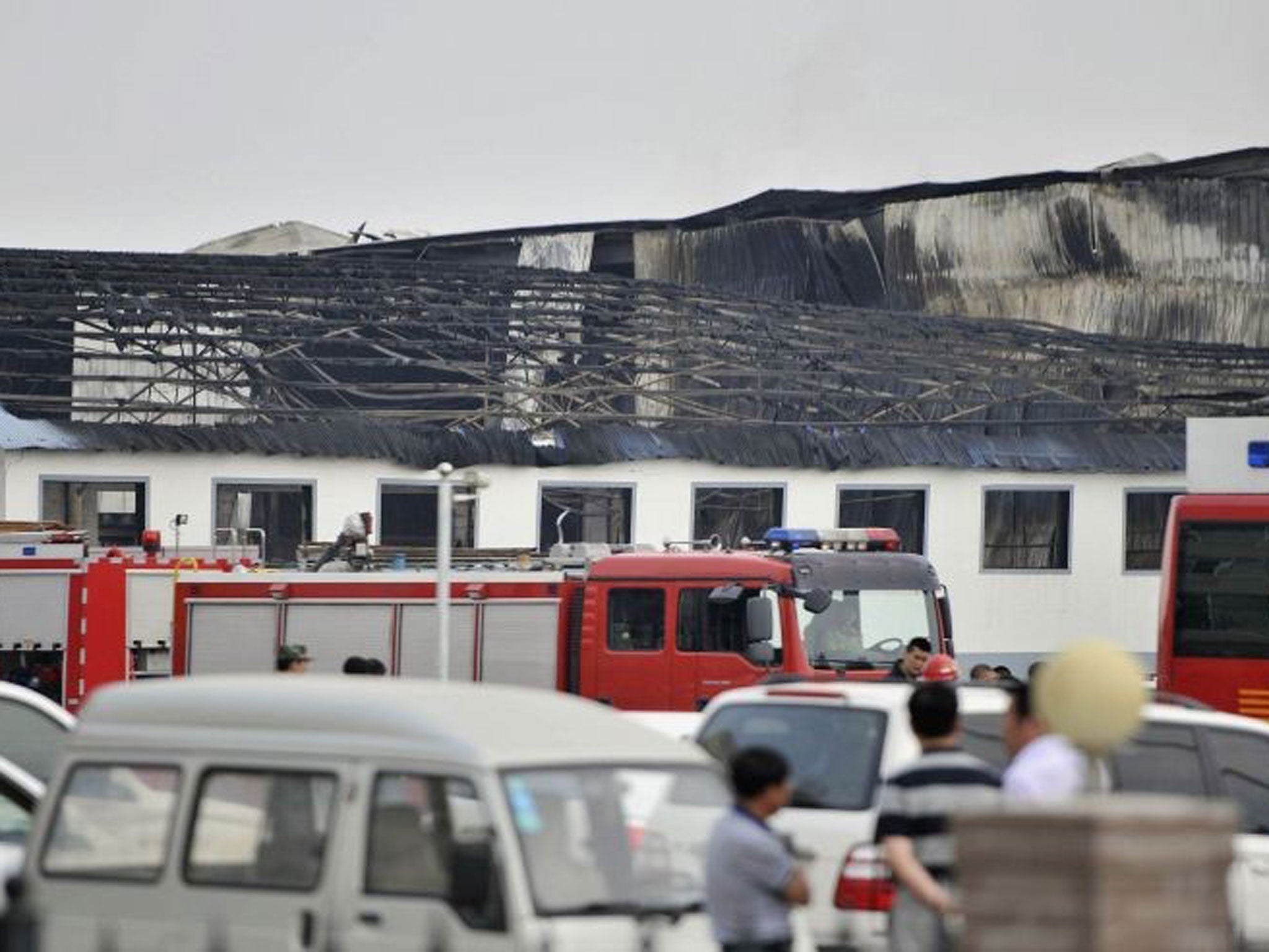 Rescue workers and fire trucks are seen outside a site of a fire, at a poultry slaughterhouse in Dehui, Jilin