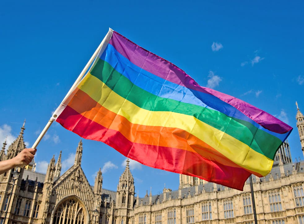 A supporter of same-sex marriage waves a rainbow flag outside the Houses of Parliament