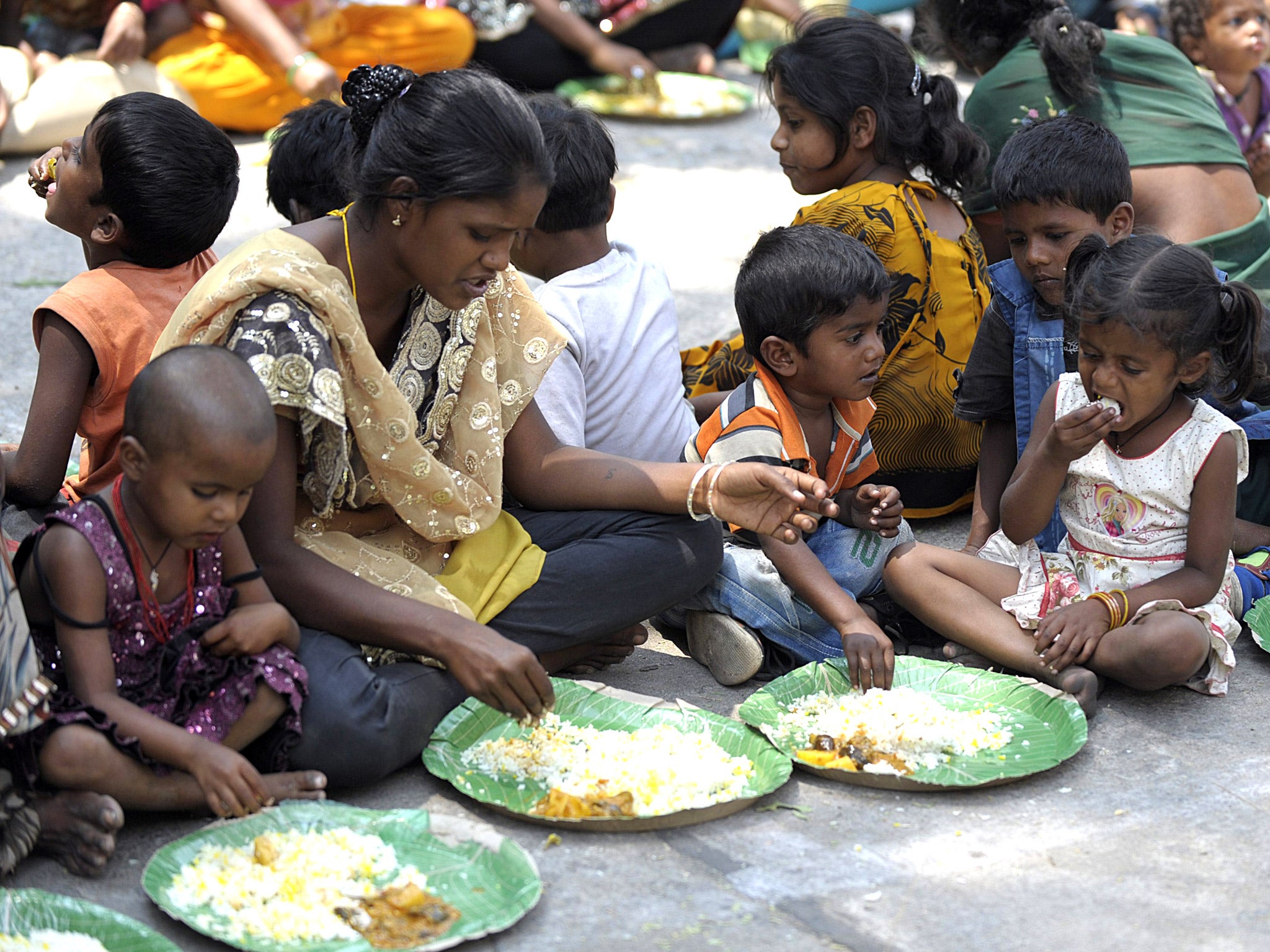 Indian homeless eat food at a feeding programme for the poor in Hyderabad