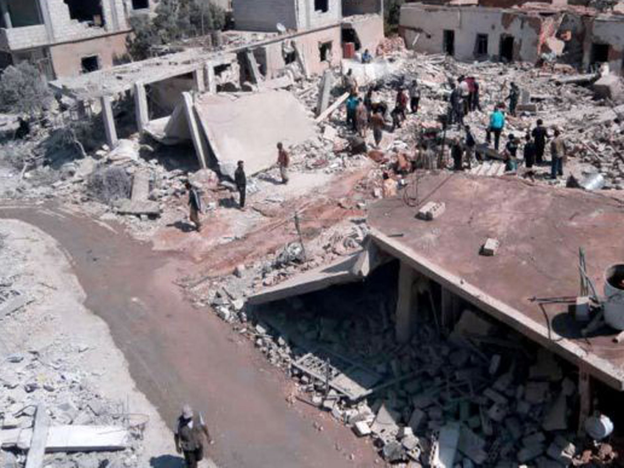 Syrian citizens inspect the site of an air strike in Qusair last month