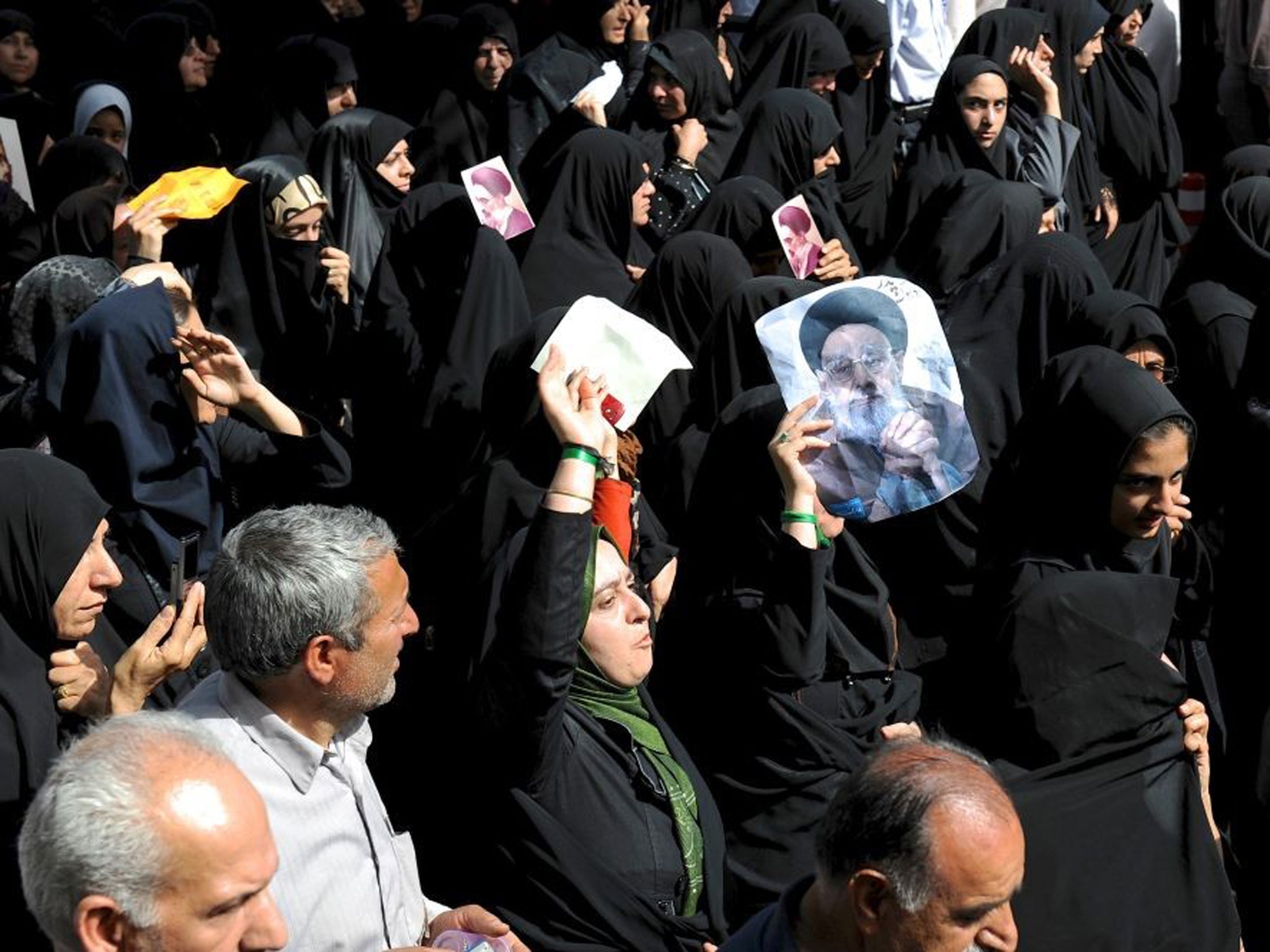 Iranian women hold portraits of Ayatollah Jalaleddin Taheri during his funeral i