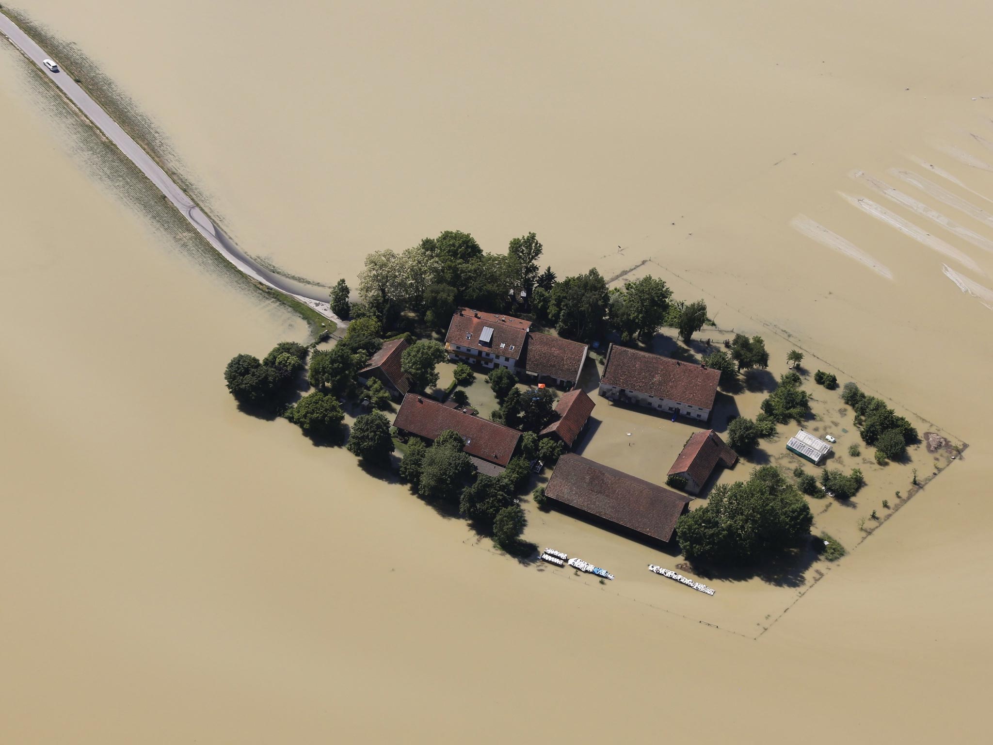 A car leaves a small settlement surrounded by the floods of the river Danube near the eastern Bavarian city of Deggendorf