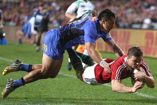 Brian O’Driscoll dives over for a Lions try despite the attention of Sam Christie