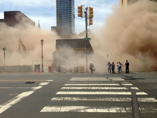 Dust cloud rises as people run from the scene of a building collapse on the edge of downtown Philadelphia