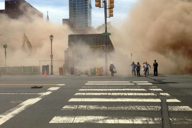 Dust cloud rises as people run from the scene of a building collapse on the edge of downtown Philadelphia