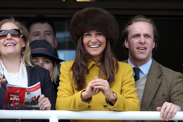Pippa Middleton (C) and Tom Kingston (R) watch the races at Cheltenham Racecourse on the third day of the Cheltenham Festival 2013 on March 14, 2013 in Cheltenham, England.