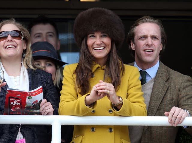 Pippa Middleton (C) and Tom Kingston (R) watch the races at Cheltenham Racecourse on the third day of the Cheltenham Festival 2013 on March 14, 2013 in Cheltenham, England.