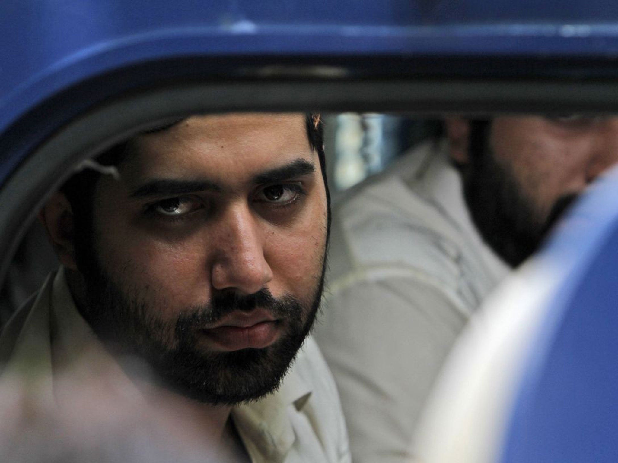 Nawab Siraj Talpur, convicted of killing 20-year-old Shahzeb Khan, looks out a police vehicle outside an Anti-Terrorism court in Karachi