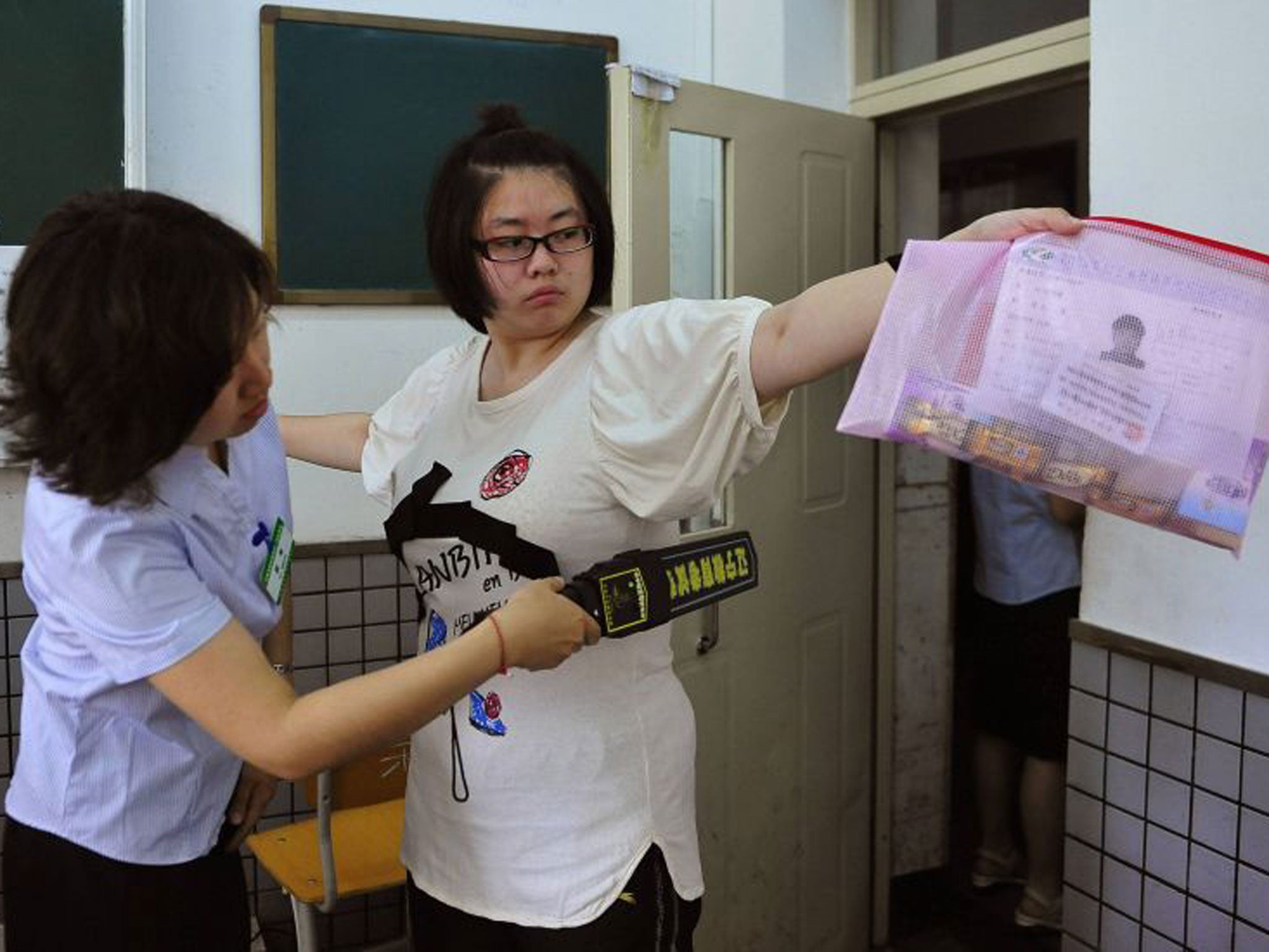 A student goes through a security check as she enters an exam room in Shenyang