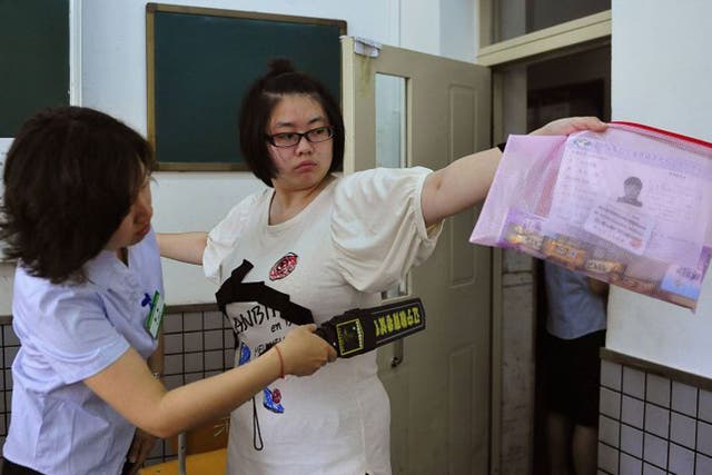 A student goes through a security check as she enters an exam room in Shenyang 