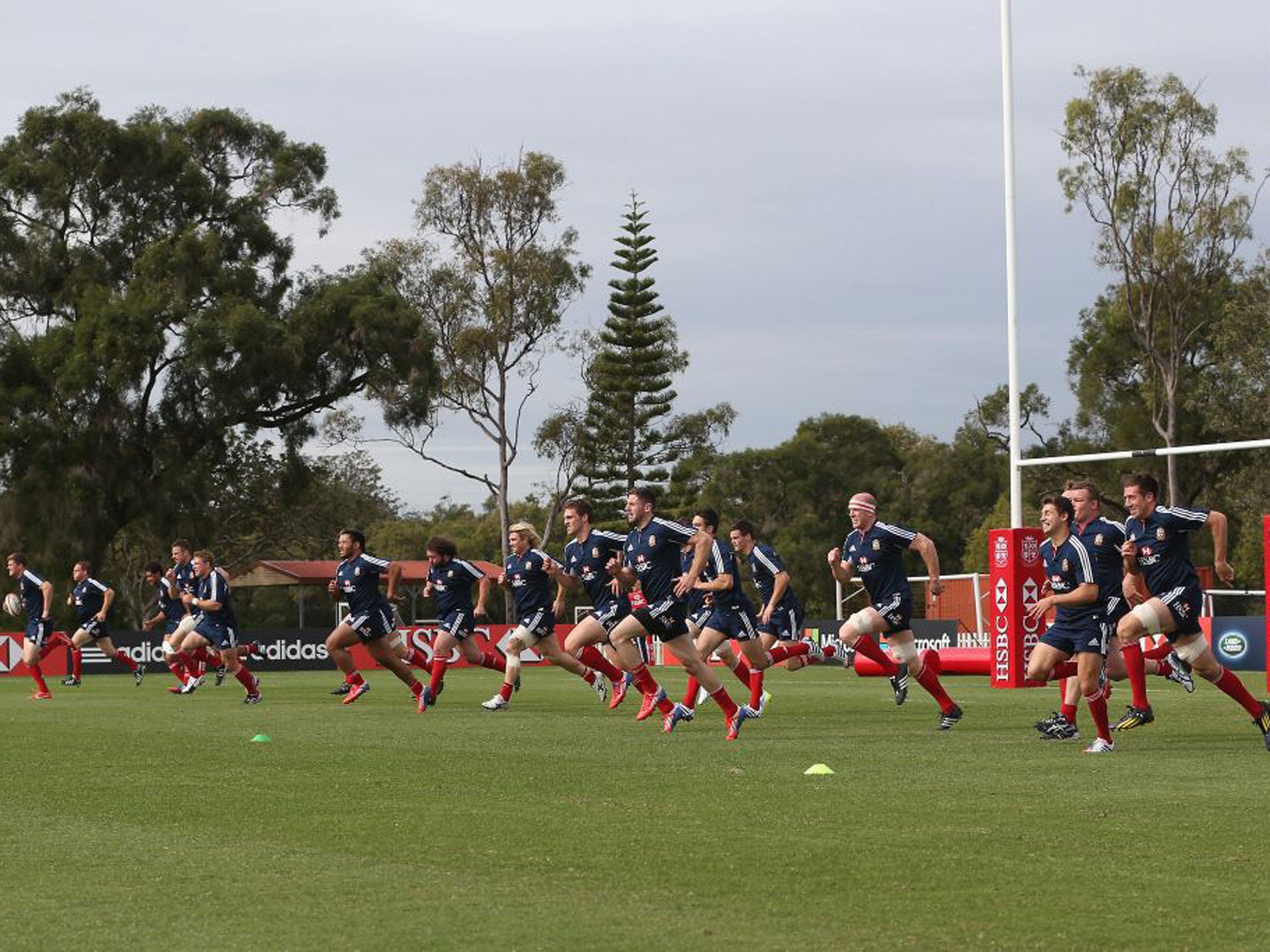 The Lions players warm up during training in Brisbane yesterday