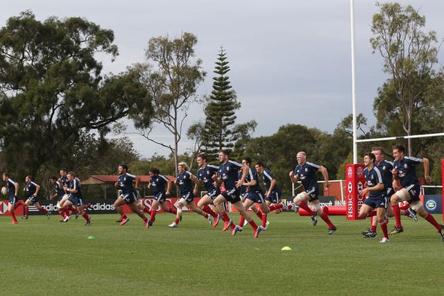 The Lions players warm up during training in Brisbane yesterday
