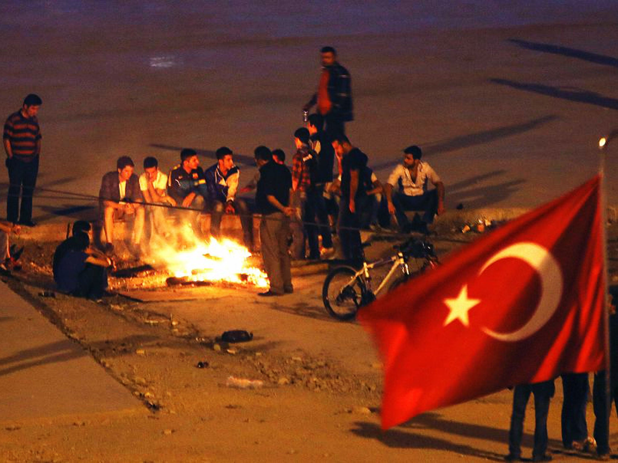 Anti-government protesters try to keep warm by a bonfire in Istanbul's Taksim square