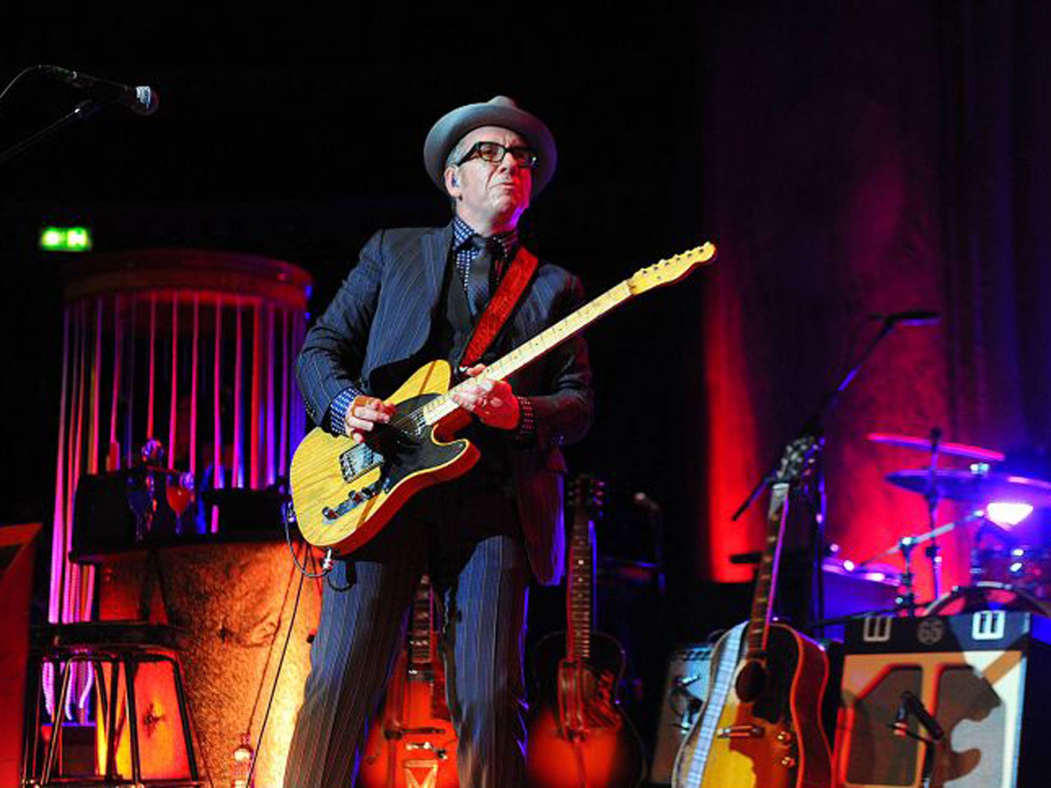 Elvis Costello plays his hits to a backdrop that’s half funfair, half supper-club