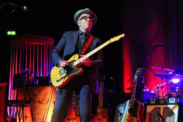 Elvis Costello plays his hits to a backdrop that’s half funfair, half supper-club